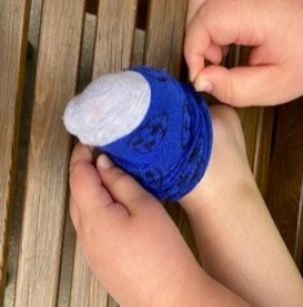Child placing the sock over their toes
