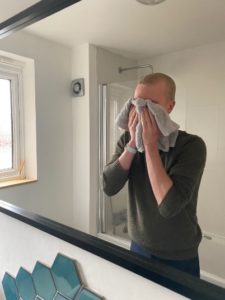 Person drying their face with a towel