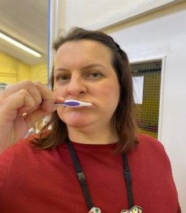 Person gently brushing their teeth in a circular motion