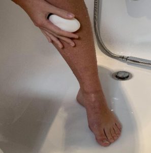 Person lathering their leg with soap