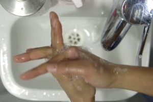 Person rubbing their hands together and cleaning in between their fingers