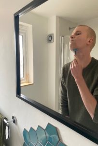 Person shaving their face in a downwards motion
