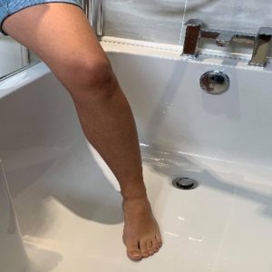 Person standing with their leg in the bath