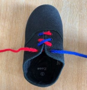 Picture shows a shoe with a red lace on the left and a blue lace on the right