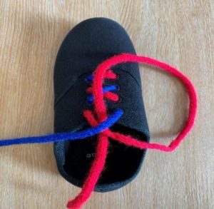 Picture shows the end of the red lace placed under the X