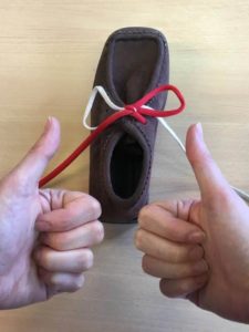 Picture shows the laces fully tied and someone with their thumbs up