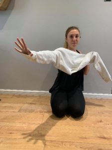 Girl pushing one hand through the arm of the jumper